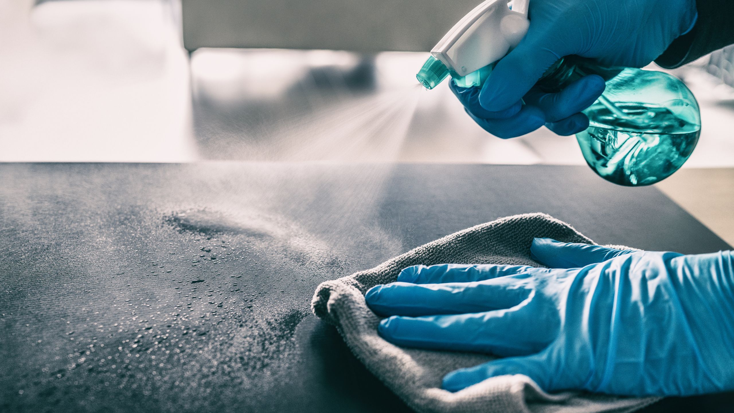 Disinfection Cleaning Services in Dayton – technician applying disinfectant spray on office desk