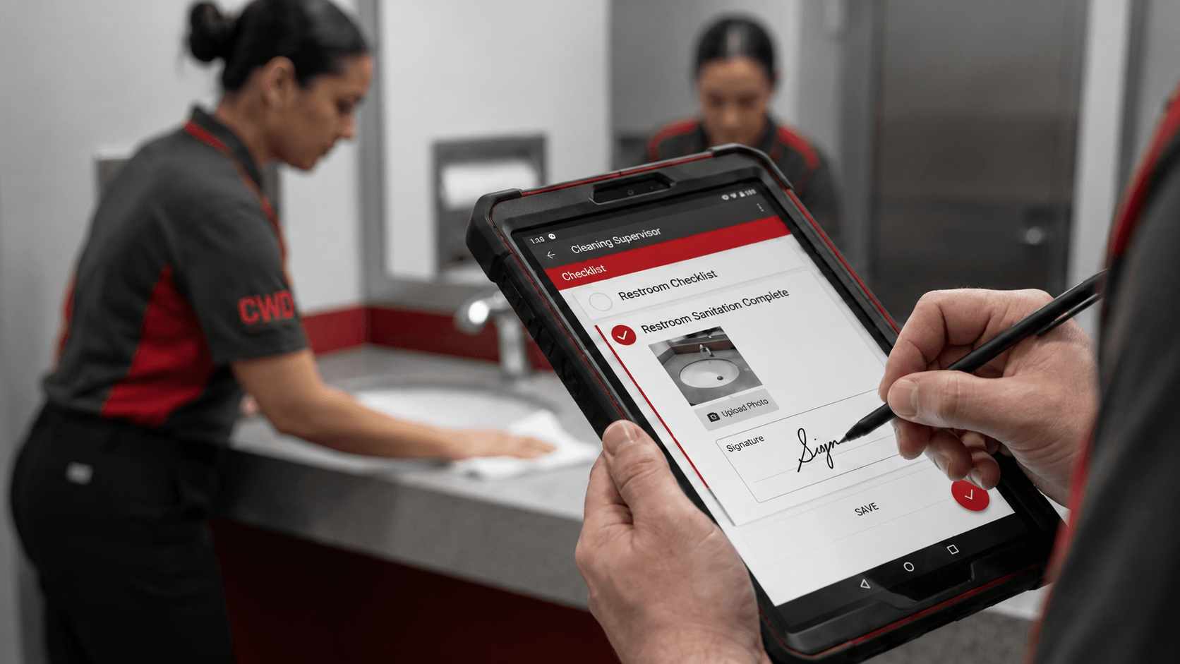 Commercial cleaning quality control inspection with supervisor reviewing a checklist on a tablet in a restroom Commercial cleaning quality control inspection with supervisor reviewing a checklist on a tablet in a restroom